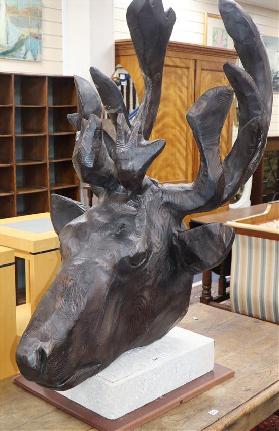 A large carved cedar wood head of an Elk, on white marble plinth H.130cm